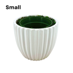 Image of a small glossy white ribbed ceramic container, containing faux moss and a green nursery pot, shown as House of Silk Flowers' pot-in-a-pot system.