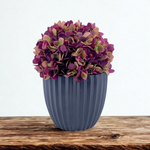 Artificial hydrangea with varying purple colors in a Matte Black Ribbed Ceramic, on a wooden countertop with a white background, by House of Silk Flowers