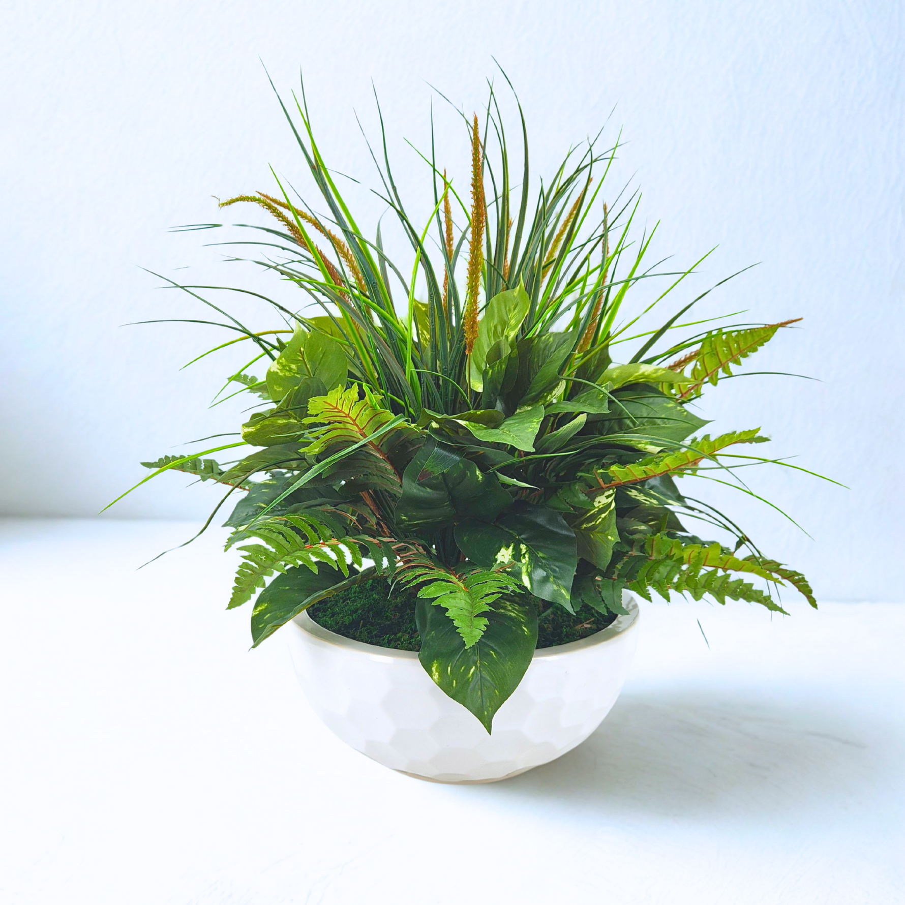 Artificial Mixed Greenery in Glossy White Dimpled Ceramic Bowl placed in front of a white backdrop, by House of Silk Flowers.