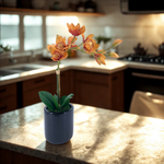 Artificial Orange Orchid in a glossy black ceramic pot on a kitchen counter, by House of Silk Flowers.