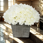 White flowers in a gray pot on a kitchen counter