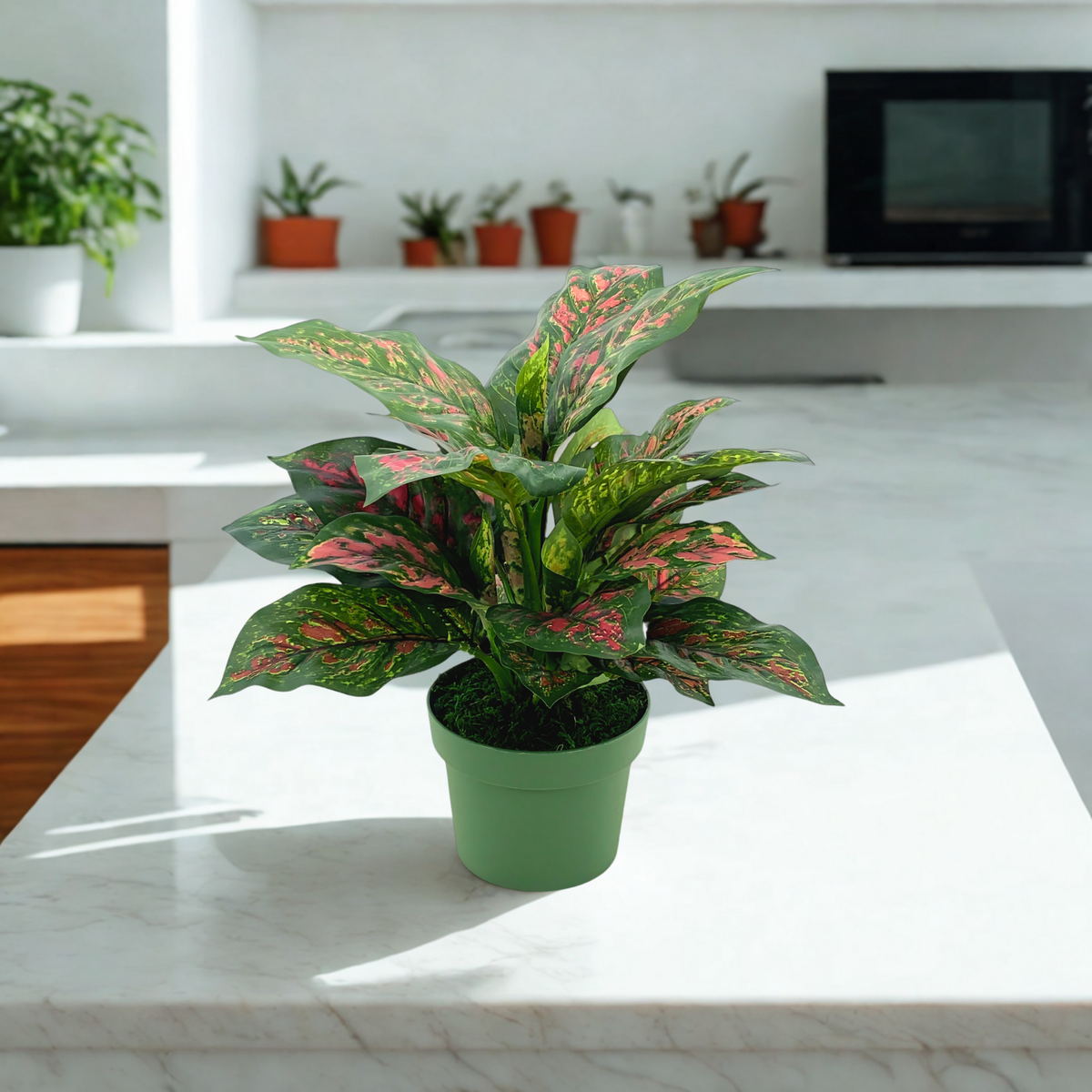 Faux Pink & Green Dieffenbachia in a green nursery pot, sitting on a white marble countertop, by House of Silk Flowers.