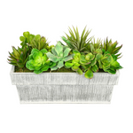 Faux succulent arrangement in a rectangular white planter on a white background