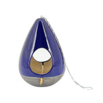 A blue ceramic teardrop-shaped birdhouse with a metal chain attached to it for hanging.